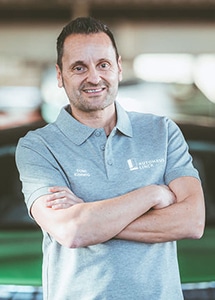 Ein Mann mit grauen Polo-Shirt und der Aufschrift Autohaus Linck