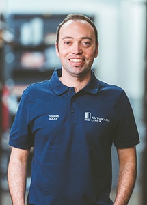 Mitarbeiter mit blauen Polo-Shirt und dem weißen Schriftzug Autohaus Linck